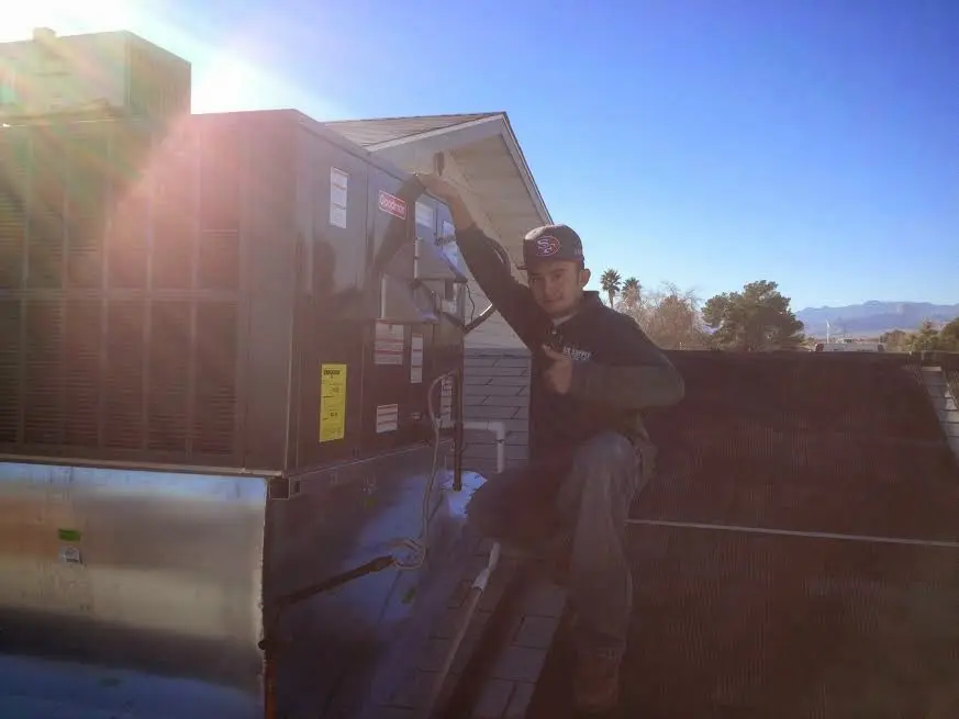 HVAC technician performing Air Duct Cleaning on a rooftop unit in La Palma